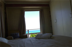 Ocean view  from the main bedroom with a queen size bed.